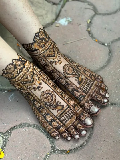 Bridal mehendi isn't complete without adorning the feet. This design features detailed paisley and traditional motifs, creating an elegant look that complements the bride's attire.