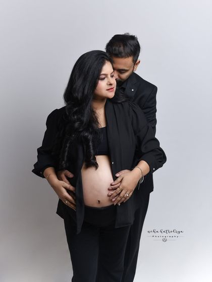 A modern and stylish maternity portrait. The all-black outfits create a chic, cohesive look, and the pose beautifully and tastefully showcases the baby bump.