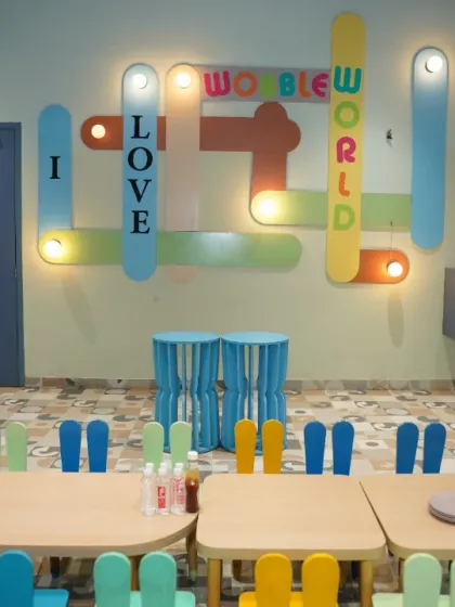 Our "I Love Wobble World" light-up sign is a favorite photo spot. This area shows our dedicated kid-friendly seating, perfect for party meals and activities.