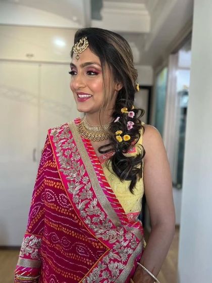 A smiling portrait of the Mehendi bride. The pink and yellow color combination is classic and joyful.