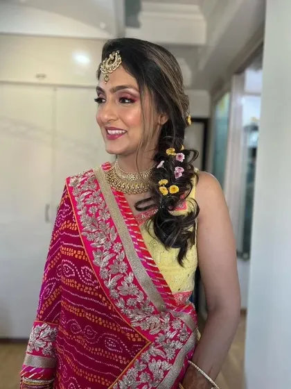 A smiling portrait of the Mehendi bride. The pink and yellow color combination is classic and joyful.