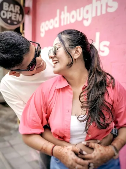 A fun and playful candid shot taken at a quirky cafe in Mumbai. This photo captures the couple's joyful energy and is a great example of a casual urban pre-wedding shoot.