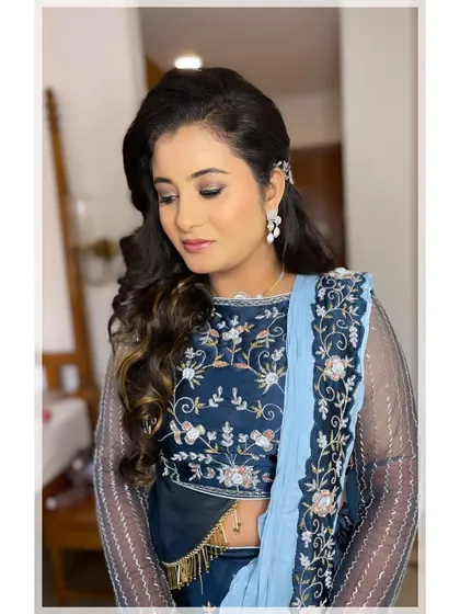 Another angle of this glowing Sangeet look. The half-up hairstyle is adorned with a delicate pearl accessory, adding a touch of elegance to the voluminous curls.
