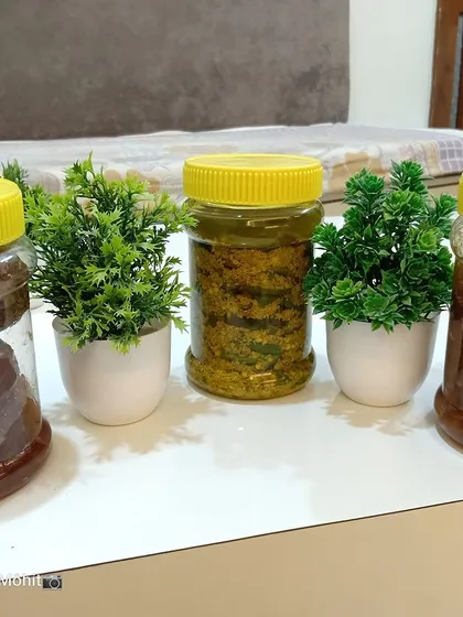 Here are three of my products, ready to be sent to a new home. You can see the whole Amla Murabba, Hari Mirchi ka Achar, and grated Mango Murabba, each in its own clear jar.