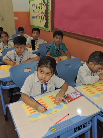 Students are deeply engaged in a classroom writing activity. We provide a structured yet creative environment to develop strong foundational literacy skills.