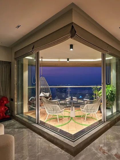 This corner balcony is designed to be a peaceful escape overlooking the Mumbai skyline. We selected comfortable all-weather seating and a hanging swing chair to create the perfect spot to unwind and enjoy the city view at dusk.