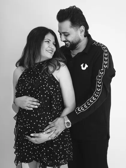 A classic black and white portrait of a couple sharing a loving gaze. This timeless style focuses on the deep connection and emotion between the soon-to-be parents.