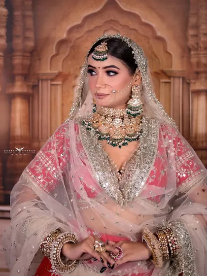 A portrait capturing the bride's gentle gaze through her sheer, silver-embroidered dupatta.