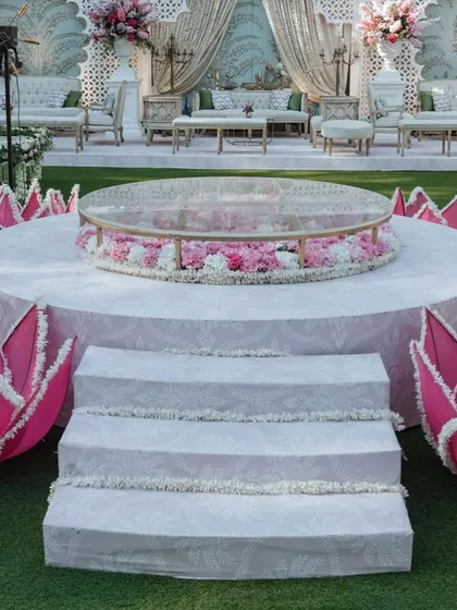 A detail of the central platform of the Lotus Mandap, featuring a glass table filled with flowers. The surrounding illuminated lotus installations add to the magical, thematic feel.
