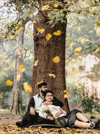 A quiet moment of togetherness under a canopy of falling autumn leaves. This image captures the soft, poetic side of romance, perfect for couples who love a simple, nature-inspired vintage aesthetic.