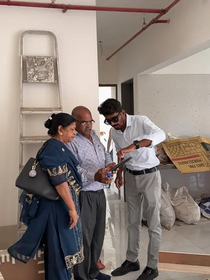 Showing the digital plans to clients on a tablet during a site visit, with construction materials in the background.