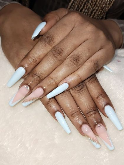 A modern and chic design on long, coffin-shaped acrylic extensions. This style combines a soft baby blue with a nude V-cut French tip, accented with a single rhinestone for a touch of sparkle.