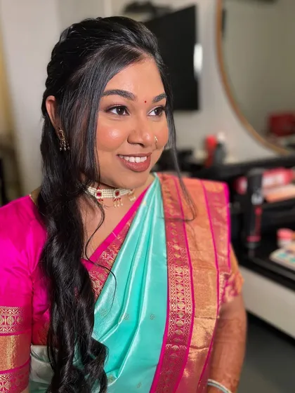A smiling bride on her engagement day. The makeup is designed to enhance her natural happiness and radiance.