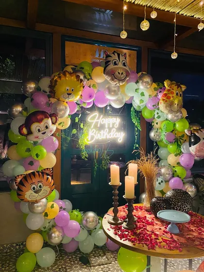 A beautiful shot of the jungle animal themed balloon arch with a neon sign.