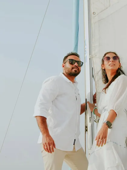 This portrait from a yacht pre-wedding shoot has a classic, windswept feel. It captures the couple looking out towards the horizon, symbolizing the start of their new journey together.