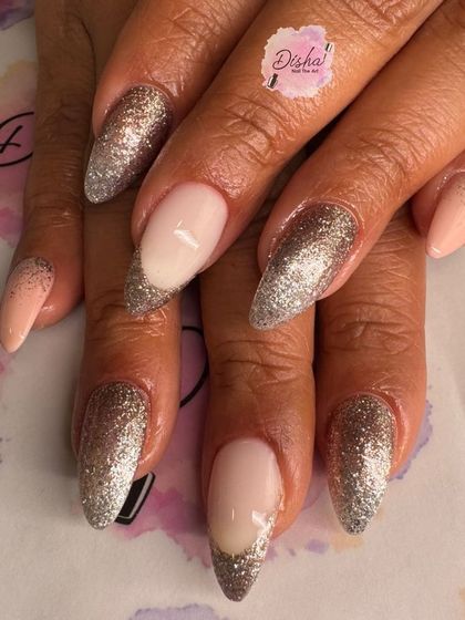 A glamorous set of almond-shaped nails with silver glitter tips.