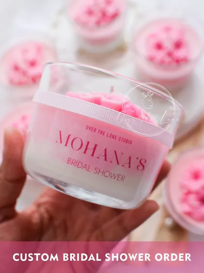 I love working on personal orders, like this custom candle for "Mohana's Bridal Shower." The ombre pink wax and detailed plumeria flowers were designed to match the event's theme perfectly.