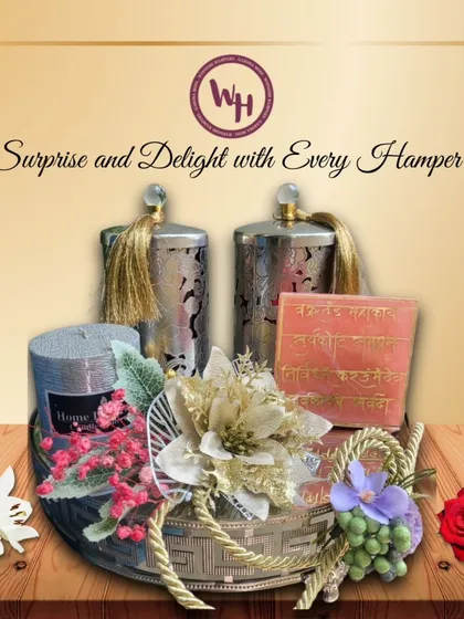 Surprise and delight with this elegant hamper. It features decorative silver canisters, a scented candle, and other curated items in a silver basket, adorned with beautiful artificial flowers for a lasting impression.