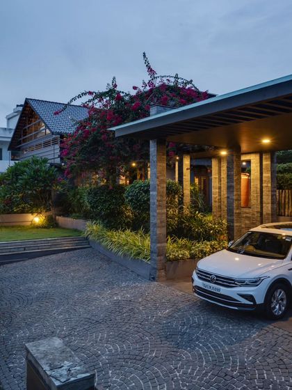 The residence at dusk, with warm lighting creating an inviting glow and highlighting the beautiful landscaping.