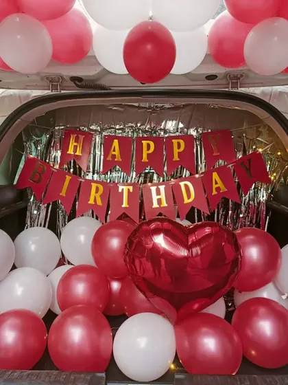A surprise birthday decoration in a car boot. I filled the space with red and white balloons, a "Happy Birthday" banner, and a shimmer curtain for a fun reveal.