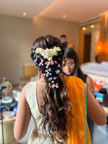 A close-up of the pastel floral braid from the beach wedding, showing the soft waves and the delicate mix of pink, blue, and white flowers.