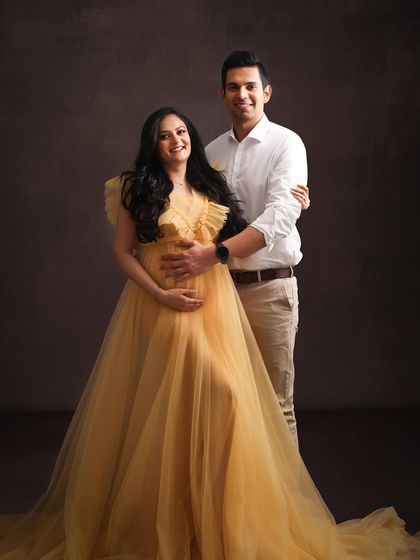 Radiating pure sunshine. This mom-to-be looks absolutely ethereal in a flowing yellow gown, creating a portrait that is full of warmth, light, and happiness.