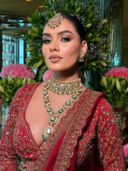 A stunning close-up of the bride. The styling highlights the smoky eye makeup and the intricate details of the layered kundan necklace.