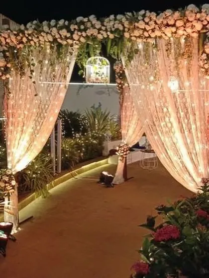 A charming entrance for a smaller, intimate event, with fairy-light-wrapped drapes and a birdcage detail.