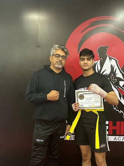 A young fighter receives his kickboxing belt, ready to continue his journey to the next level.