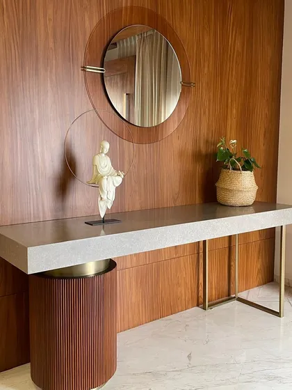 A custom console table with a micro-cement top and sleek metal legs, designed for a project by Cantilever Architects. The piece is complemented by a fluted wood pedestal, creating a play of textures and forms.