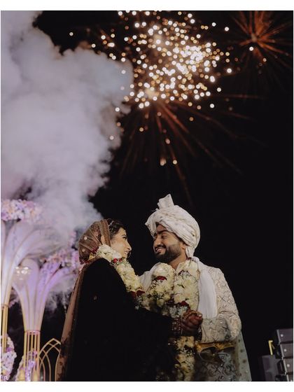 A magical end to the wedding ceremony. This shot captures the couple under a sky full of fireworks, a perfect cinematic moment that encapsulates the grandeur and romance of a destination wedding in Goa.