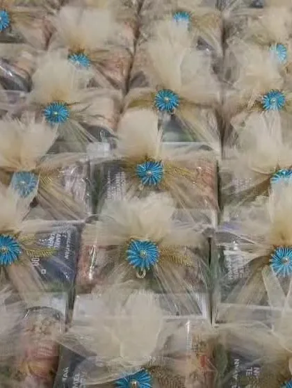 A large batch of my signature welcome hampers, uniformly wrapped and ready for a big wedding. The combination of beige netting and a bright blue flower is one of my most popular and versatile designs.