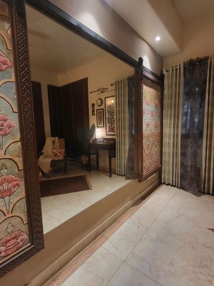 A large, full-length mirror with a traditional painted frame visually expands this room and reflects the beautiful artwork on the opposite wall.