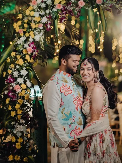 A happy and laughing couple, enjoying their Haldi celebration to the fullest.