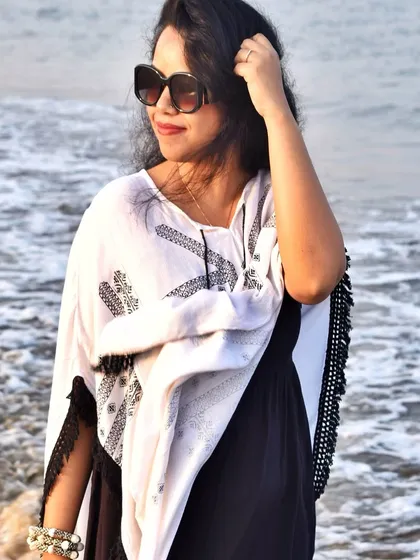 A breezy white and black kaftan-style top is the perfect cover-up for a beach day in Diu, offering a chic and comfortable boho vibe.