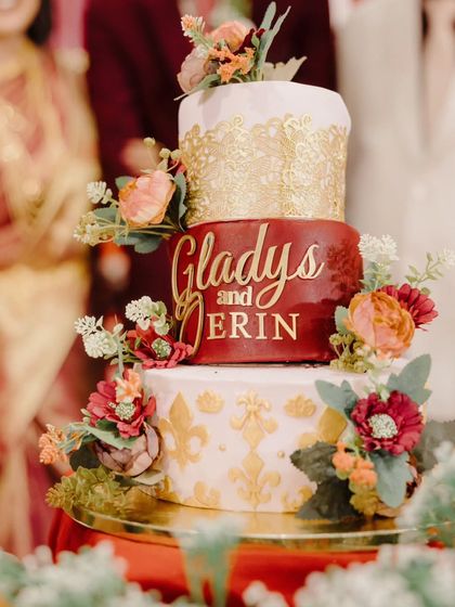 Even the cake tells a story. This magnificent three-tiered cake for Gladys and Jerin, personalized with their names and adorned with intricate gold lacework and flowers, was a centerpiece that perfectly matched their reception's elegant theme.