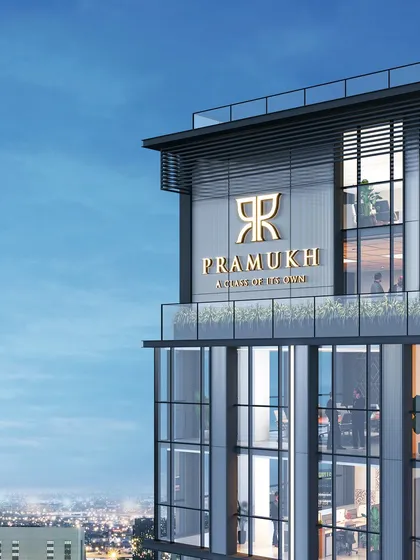 The top of the "Pramukh" commercial tower in Surat. The branding is integrated into the architecture, which is defined by a clean, modern, and minimalist design language suitable for a corporate landmark.