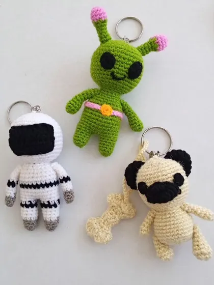 I also make small, custom crochet keychains that are perfect for gifts. This set includes a tiny astronaut, a friendly alien, and a cute pug with its own bone.
