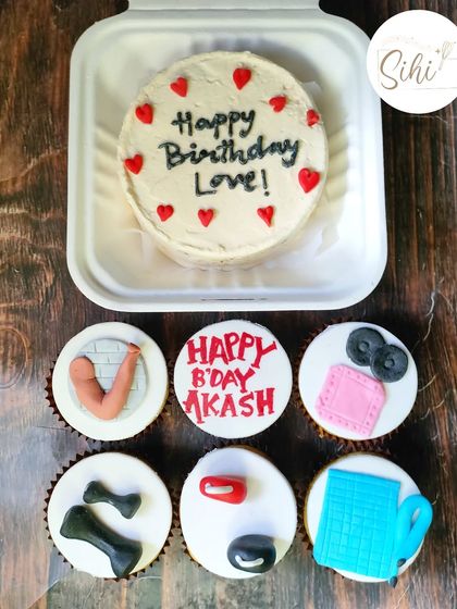 A bento and cupcake set for a fitness enthusiast. The cupcakes are topped with fondant dumbbells, towels, and other gym equipment to match the "Happy Birthday Love" bento.