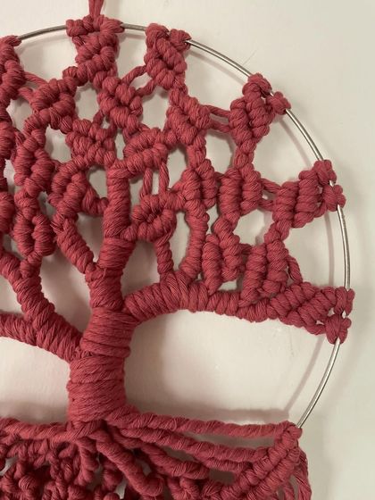 A detailed shot of the rust-colored Tree of Life. You can see the texture of the cotton cord and the complexity of the knots in the tree's canopy.