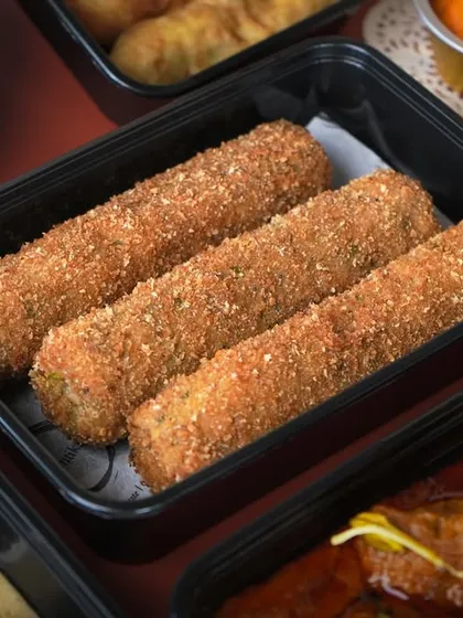 Crispy and savory Chicken Swiss Rolls, a popular starter in my Iftar boxes, shown here in a delivery container.