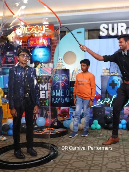 Our bubbleologist creates a giant bubble around a guest at a birthday party. This interactive part of our show is always a highlight, providing a unique experience and a great photo.