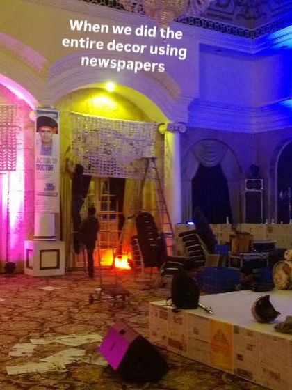 A behind-the-scenes shot of our team installing massive curtains made of woven newspaper strips. This was for a huge event where we handled the entire decor using only recycled newspapers.