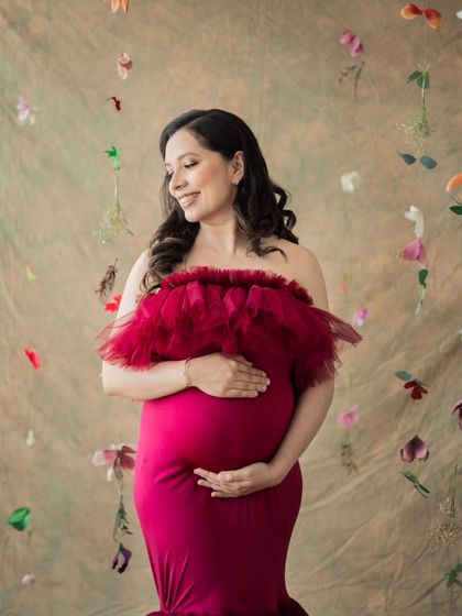 A solo portrait of a mother-to-be, surrounded by a cascade of delicate flowers. This setup adds a touch of whimsy and beauty to the maternity session.