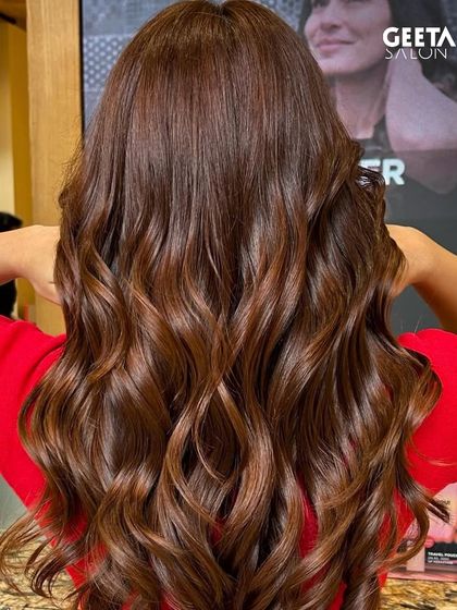 A warm, reddish-brown hue that catches the light beautifully, styled in soft, flowing waves.