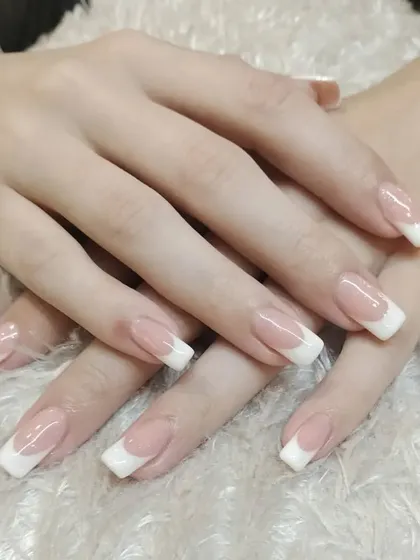 The epitome of elegance: a classic French manicure. This look is all about clean lines and a sophisticated finish, a specialty that is always in demand.