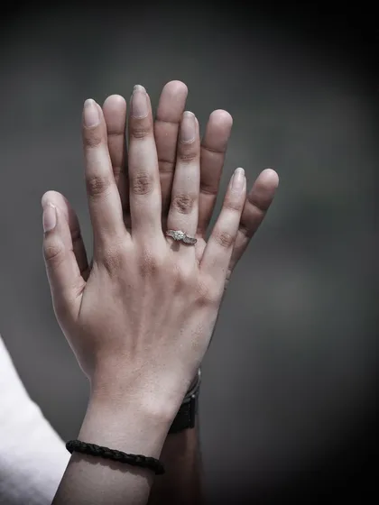 A close-up shot focusing on the couple's hands, highlighting the engagement ring and symbolizing their commitment.