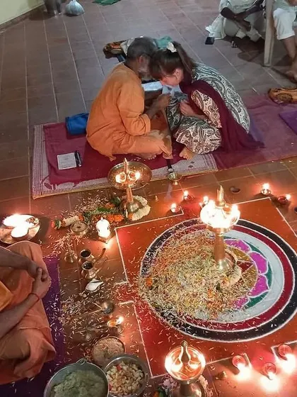 A student receives blessings during a traditional puja ceremony for our Yoga Teacher Training Course. These sacred rituals are an integral part of our curriculum, connecting us to the ancient lineage of yoga.