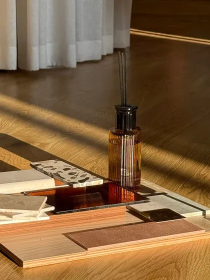 Mood boards are a glimpse into the bigger picture. This composition of wood, stone, and textile swatches, bathed in sunlight, captures the intended atmosphere of a space long before it is built.
