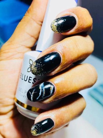 Great Gatsby themed nails. I love the black and gold aesthetic, created here with black polish, gold glitter, and a white marble accent.